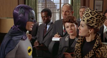Movie still from “Batman: The Movie” (1966), directed by Leslie H. Martinson – A group of people standing in a room; Medium shot, Over the shoulder angle