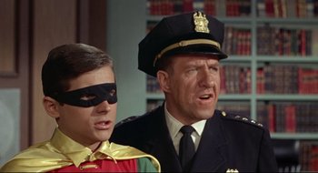 Movie still from “Batman: The Movie” (1966), directed by Leslie H. Martinson – A man and a boy wearing costumes and a uniform; Close Up shot, Low angle
