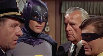 Movie still from “Batman: The Movie” (1966), directed by Leslie H. Martinson – A man in a suit and tie next to another man in a suit and tie; Medium shot, Low angle