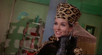 Movie still from “Batman: The Movie” (1966), directed by Leslie H. Martinson – A woman in a leopard print hat and a black coat; Close Up shot, Low angle