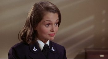 Movie still from “Batman: The Movie” (1966), directed by Leslie H. Martinson – A young woman in a uniform looking to her left; Close Up shot, High angle