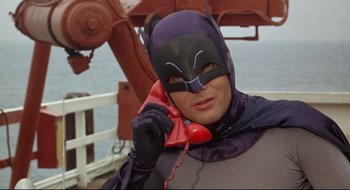 Movie still from “Batman: The Movie” (1966), directed by Leslie H. Martinson – A man dressed as batman talking on a red phone; Close Up shot, Low angle