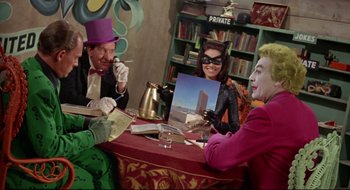 Movie still from “Batman: The Movie” (1966), directed by Leslie H. Martinson – A group of people sitting around a table; Medium shot, High angle