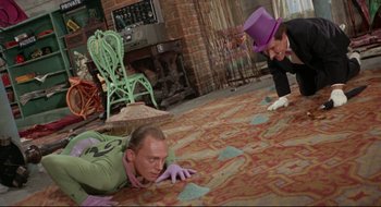Movie still from “Batman: The Movie” (1966), directed by Leslie H. Martinson – Two men are laying on the ground in a room; Medium shot, High angle