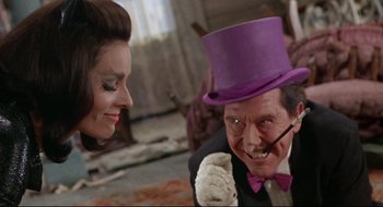 Movie still from “Batman: The Movie” (1966), directed by Leslie H. Martinson – A man in a purple top hat and a woman in a black suit; Close Up shot, Over the shoulder angle