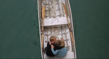 Movie still from “Batman: The Movie” (1966), directed by Leslie H. Martinson – Two people are sitting in a boat on the water; Wide shot, Overhead angle
