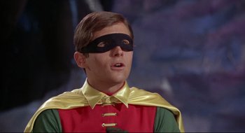 Movie still from “Batman: The Movie” (1966), directed by Leslie H. Martinson – A young man wearing a red and yellow costume and a black mask; Close Up shot, Low angle