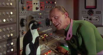 Movie still from “Batman: The Movie” (1966), directed by Leslie H. Martinson – A man and a penguin in front of a control panel; Medium shot, Low angle