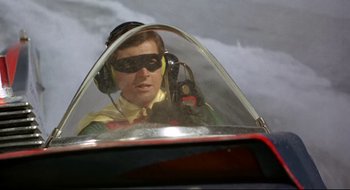 Movie still from “Batman: The Movie” (1966), directed by Leslie H. Martinson – A man in a cockpit of an airplane; Medium shot, Low angle