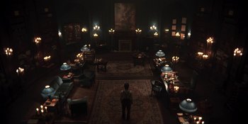 Movie still from “Dark” (2017), created by Baran bo Odar – A man standing in a room with candles on the floor; Extreme Wide shot, High angle