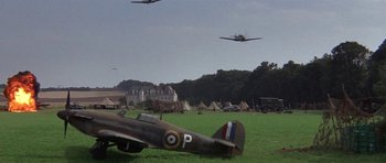 Movie still from “The Battle of Britain” (1969), directed by Guy Hamilton – A group of airplanes flying over a field; Extreme Wide shot, Low angle