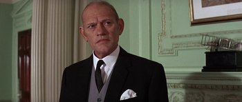 Movie still from “The Battle of Britain” (1969), directed by Guy Hamilton – An older man wearing a suit and tie; Close Up shot, Low angle