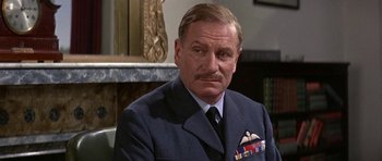 Movie still from “The Battle of Britain” (1969), directed by Guy Hamilton – An older man wearing a suit and tie; Close Up shot, Low angle