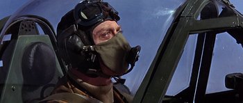 Movie still from “The Battle of Britain” (1969), directed by Guy Hamilton – A man wearing a pilot's helmet while looking out a window; Close Up shot, Low angle