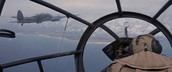 Movie still from “The Battle of Britain” (1969), directed by Guy Hamilton – An airplane flying over a body of water; Wide shot, Low angle