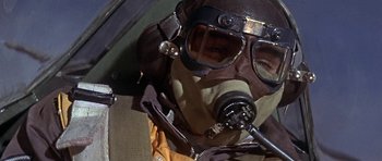 Movie still from “The Battle of Britain” (1969), directed by Guy Hamilton – A man wearing a gas mask and goggles in an airplane; Close Up shot, Low angle