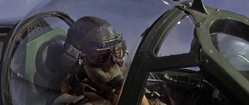 Movie still from “The Battle of Britain” (1969), directed by Guy Hamilton – A man in a fighter jet wearing goggles and a helmet; Medium shot, Low angle