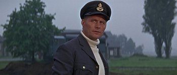Movie still from “The Battle of Britain” (1969), directed by Guy Hamilton – A man wearing a hat and a jacket; Close Up shot, Low angle
