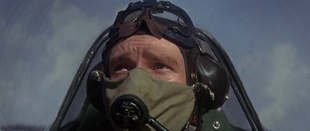 Movie still from “The Battle of Britain” (1969), directed by Guy Hamilton – An older man wearing an air force helmet and goggles; Close Up shot, Low angle