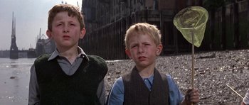 Movie still from “The Battle of Britain” (1969), directed by Guy Hamilton – Two young boys standing next to each other on a beach; Medium shot, Low angle