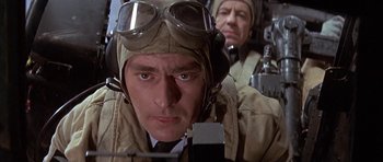 Movie still from “The Battle of Britain” (1969), directed by Guy Hamilton – A man in military uniform and goggles looking at the camera; Close Up shot, Low angle