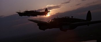 Movie still from “The Battle of Britain” (1969), directed by Guy Hamilton – Two planes flying in the air at sunset; Extreme Wide shot, Low angle