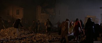 Movie still from “The Battle of Britain” (1969), directed by Guy Hamilton – A group of people walking through a pile of rubble; Wide shot, High angle