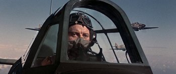 Movie still from “The Battle of Britain” (1969), directed by Guy Hamilton – A man in a fighter pilot's helmet looking out of the cockpit of an airplane; Close Up shot, Low angle