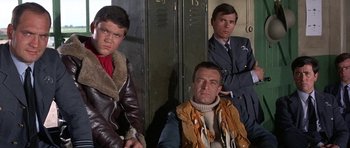 Movie still from “The Battle of Britain” (1969), directed by Guy Hamilton – A group of men sitting next to each other in front of lockers; Medium shot, Low angle