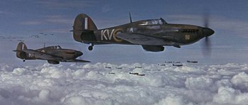Movie still from “The Battle of Britain” (1969), directed by Guy Hamilton – A group of planes flying in the sky above the clouds; Extreme Wide shot, High angle