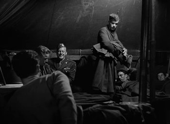 Movie still from “Battleground” (1949), directed by William A. Wellman – A group of men sitting on top of a bed; Medium shot, Over the shoulder angle