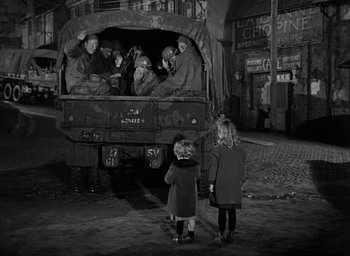 Movie still from “Battleground” (1949), directed by William A. Wellman – A group of people sitting in the back of a truck; Wide shot, High angle