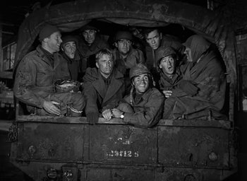 Movie still from “Battleground” (1949), directed by William A. Wellman – A group of men sitting in the back of a truck; Medium shot, High angle