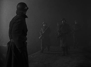 Movie still from “Battleground” (1949), directed by William A. Wellman – A black and white photo of a group of soldiers; Medium shot, Low angle