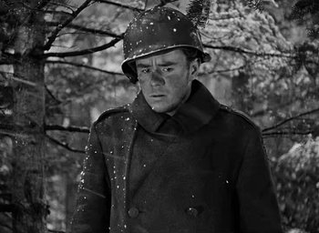 Movie still from “Battleground” (1949), directed by William A. Wellman – A man wearing a hat and a coat in the snow; Medium shot, Low angle