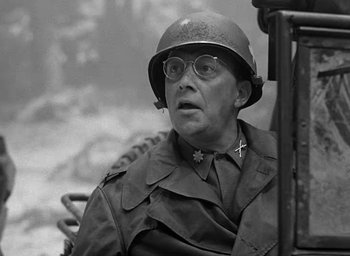 Movie still from “Battleground” (1949), directed by William A. Wellman – A man wearing a helmet and glasses sitting in a chair; Close Up shot, Low angle