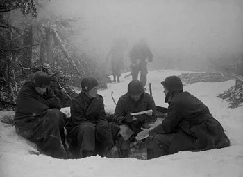 Movie still from “Battleground” (1949), directed by William A. Wellman – A black and white photo of soldiers in the snow; Medium shot, High angle