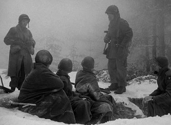 Movie still from “Battleground” (1949), directed by William A. Wellman – A black and white photo of a group of soldiers in the snow; Wide shot, Over the shoulder angle