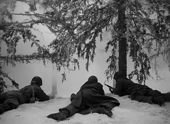Movie still from “Battleground” (1949), directed by William A. Wellman – A group of men sitting in the snow next to a tree; Wide shot, High angle