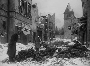 Movie still from “Battleground” (1949), directed by William A. Wellman – An old photo of people standing in the rubble; Wide shot, High angle