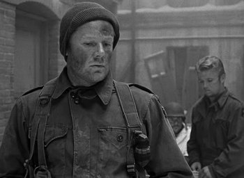 Movie still from “Battleground” (1949), directed by William A. Wellman – A man wearing a hat and a jacket; Medium shot, Over the shoulder angle