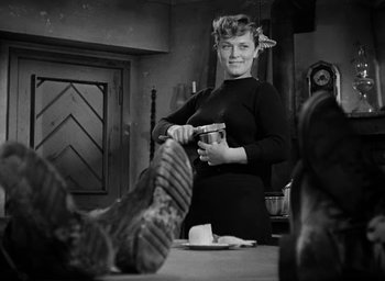 Movie still from “Battleground” (1949), directed by William A. Wellman – A black and white photo of a woman cutting a cake; Medium shot, Low angle