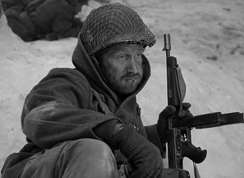Movie still from “Battleground” (1949), directed by William A. Wellman – A man with a rifle sitting in the snow; Close Up shot, High angle