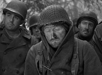 Movie still from “Battleground” (1949), directed by William A. Wellman – An old photo of a man with a helmet on; Close Up shot, Low angle