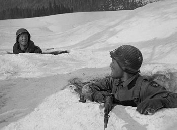 Movie still from “Battleground” (1949), directed by William A. Wellman – Two men in the snow with guns and a rifle; Medium shot, High angle