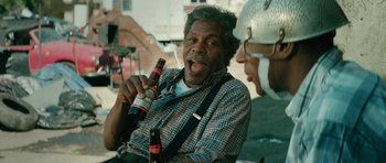 Movie still from “Be Kind Rewind” (2008), directed by Michel Gondry – A man holding a bottle of beer while sitting next to another man; Close Up shot, Over the shoulder angle