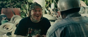 Movie still from “Be Kind Rewind” (2008), directed by Michel Gondry – A man wearing a hat is sitting at a table with a beer; Close Up shot, Over the shoulder angle