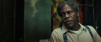 Movie still from “Be Kind Rewind” (2008), directed by Michel Gondry – An older man wearing a neck tie in front of a painting; Close Up shot, Over the shoulder angle