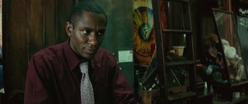 Movie still from “Be Kind Rewind” (2008), directed by Michel Gondry – A man wearing a tie sitting in front of a painting; Close Up shot, Low angle