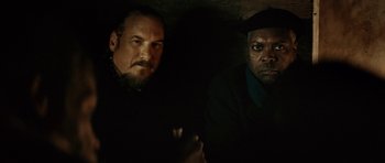 Movie still from “Be Kind Rewind” (2008), directed by Michel Gondry – Two men in a dimly - lit room , one of them holding a gun; Close Up shot, Over the shoulder angle